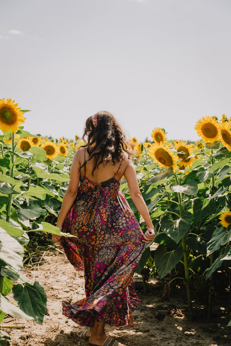 Girl running through a field of sunflowers - summer skin tips with natural organic vegan products